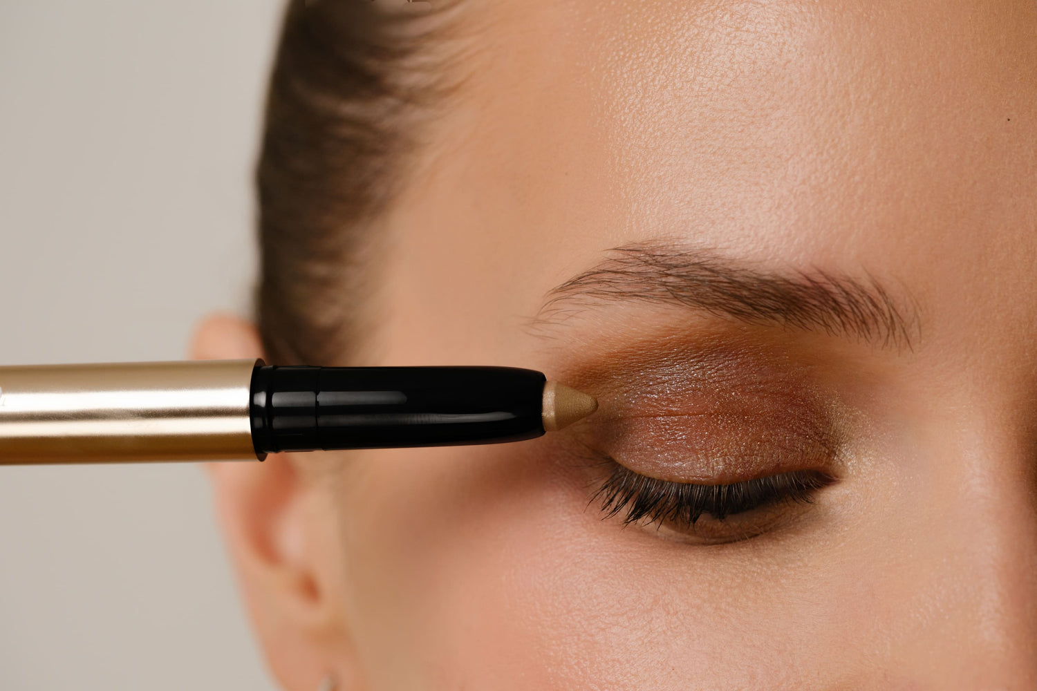 Person applying makeup with a brush to their eye