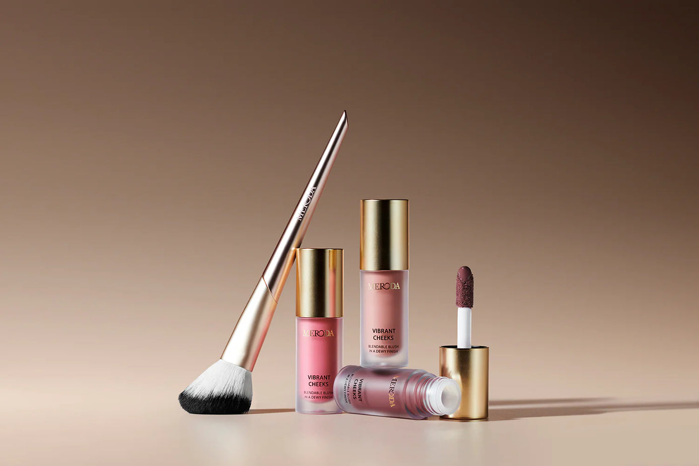 Vibrant Cheeks Blush Brush with synthetic bristles and gold handle alongside three Vibrant Cheeks Liquid Blush bottles.