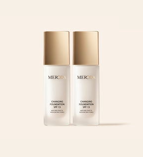 Two Meroda Changing Foundation bottles with gold caps displayed side by side on a neutral background.