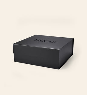 Matte black Gift Box featuring an embossed MERODA logo on the lid on a cream background.