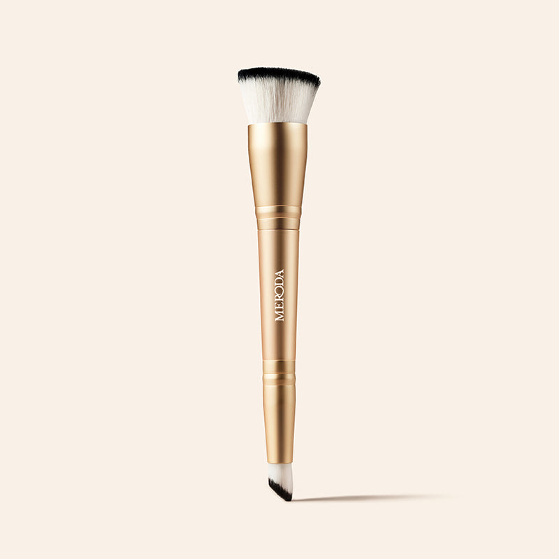 Meroda Cosmetics 2-in-1 Build & Conceal Brush featuring a gold handle and dual-ended bristles on a light background
