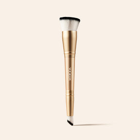 Meroda Cosmetics 2-in-1 Build & Conceal Brush featuring a gold handle and dual-ended bristles on a light background