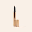 Eye Perfecting Shimmer Stick in Champagne with the gold cap removed to reveal the shimmering, creamy tip.
