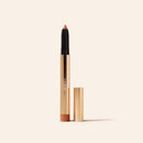 Eye Perfecting Shimmer Stick in Gold with the cap removed to show the radiant, light-reflecting cream tip.
