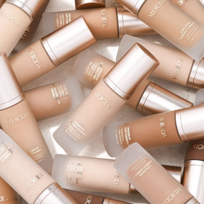 Universal Foundation in various shades in frosted glass bottles with rose gold caps for a natural matte finish.