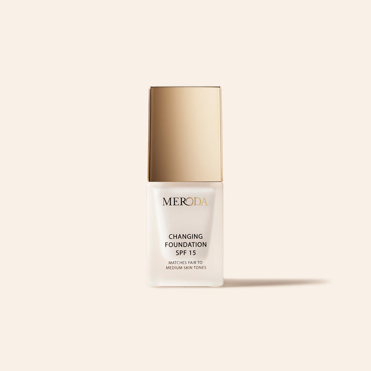 Meroda Mini Changing Foundation with SPF 15 in a white bottle and gold cap for fair to medium skin tones.