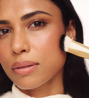 Close-up of model blending makeup on cheek using Meroda Cosmetics The Essential Brush