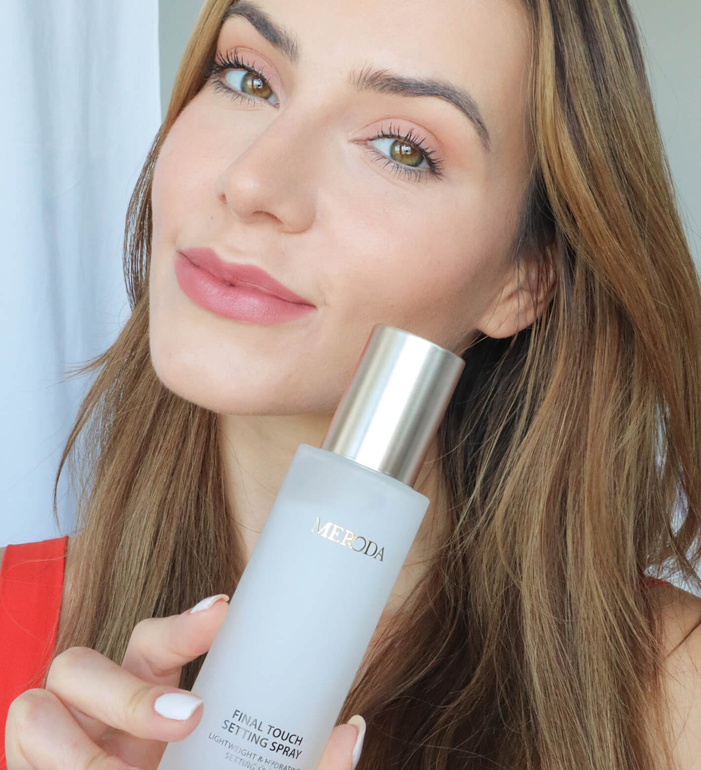 Woman holding Final Touch Setting Spray to lock in makeup for a fresh, radiant look