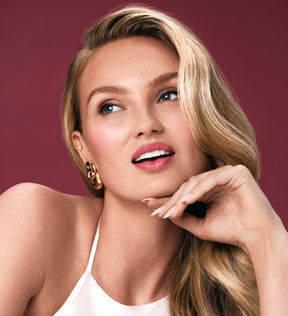 Blonde model showcasing a radiant makeup look from the Advent Calendar with glowing skin and pink lips.