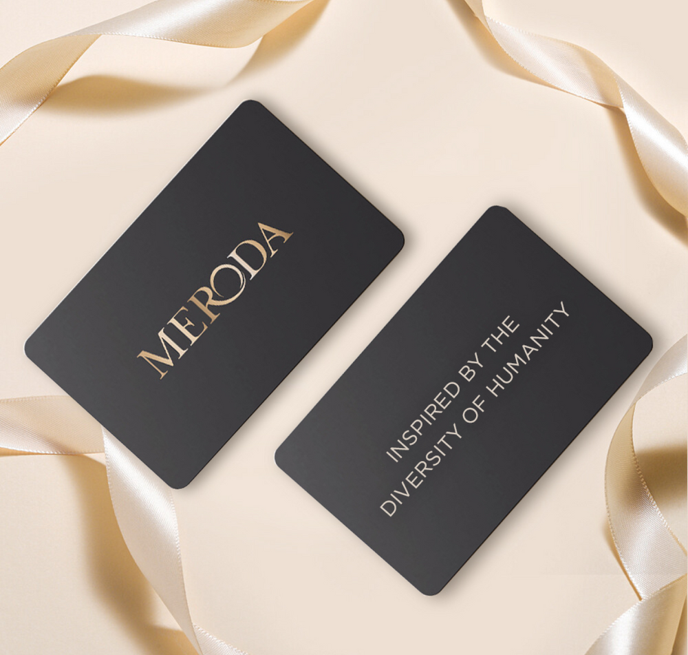 Meroda E-Gift Card featuring black and gold cards with slogan, surrounded by elegant cream satin ribbons.